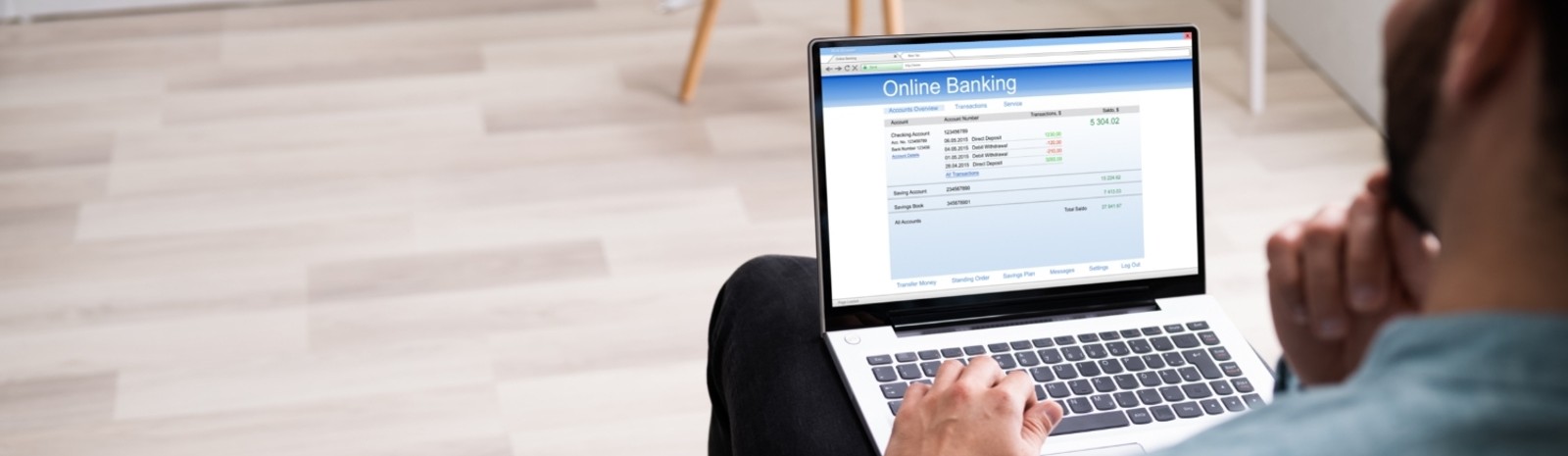 Man looking at online banking statement on laptop
